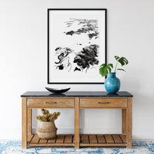 Load image into Gallery viewer, A black and white illustrated print of Bay of Plenty, laid out on white paper within a black frame, hanging above a rustic wooden console table with a blue vase holding green leaves, a woven basket with dried plants, and a decorative black bowl.