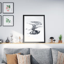Load image into Gallery viewer, A black and white illustrated print of Mt Maunganui laid out on white paper framed in a black frame leaning on a white wall and a shelf above a sofa.