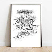 Load image into Gallery viewer, A black and white illustrated print of Ōpōtiki laid out on white paper, framed in a black frame, leaning on a white wall and wooden flooring.