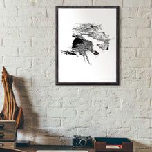 Load image into Gallery viewer, A black and white illustrated print of Queenstown laid out on white paper within a black frame hanging on a white brick wall above a desk setting.