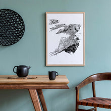 Load image into Gallery viewer, A black and white illustrated print of Wellington City laid out on white paper within a wooden frame hung on a duck egg blue wall, above a table setting.